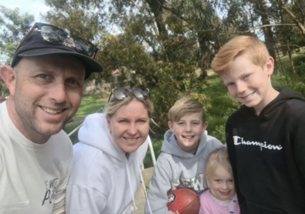 Family in park training for the Be Wise Walk, looking to camera